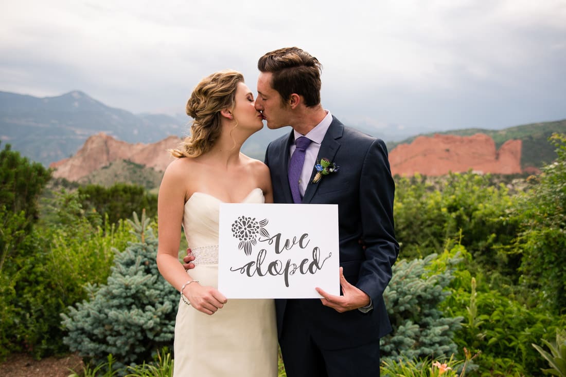 bride and groom holding a we eloped sign
